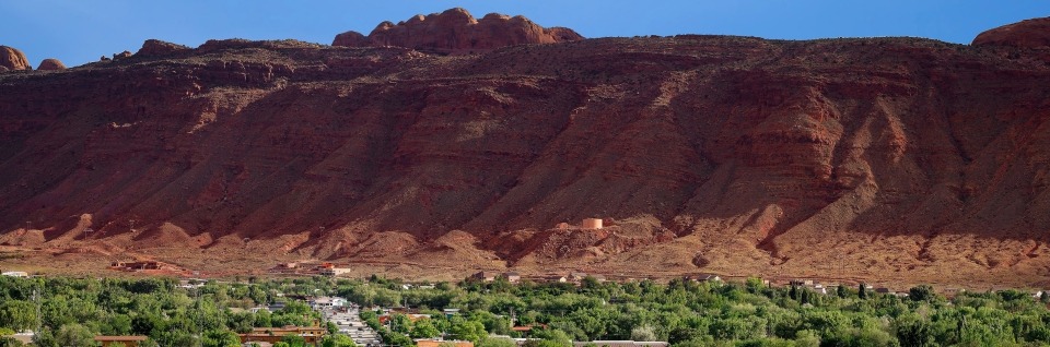 Towering red rock over the township of Moab, Utah, USA