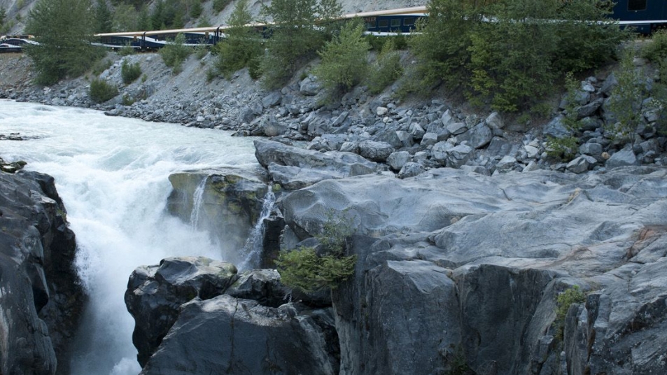 A powerful river flowing through a rocky gorge, with lush greenery on the banks