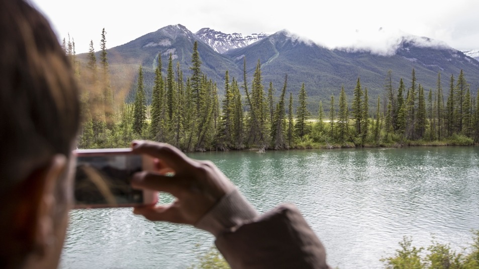 Guest taking a photo off the side of Rocky Mountaineer train
