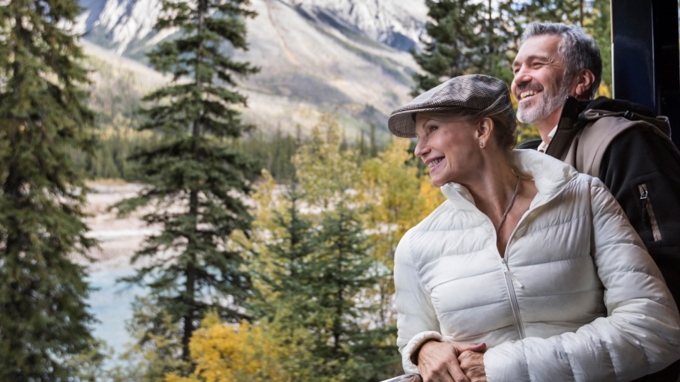Couple enjoying a breathtaking view from a train near Banff and Lake Louise.