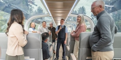 Host and guests in glass-dome train coach