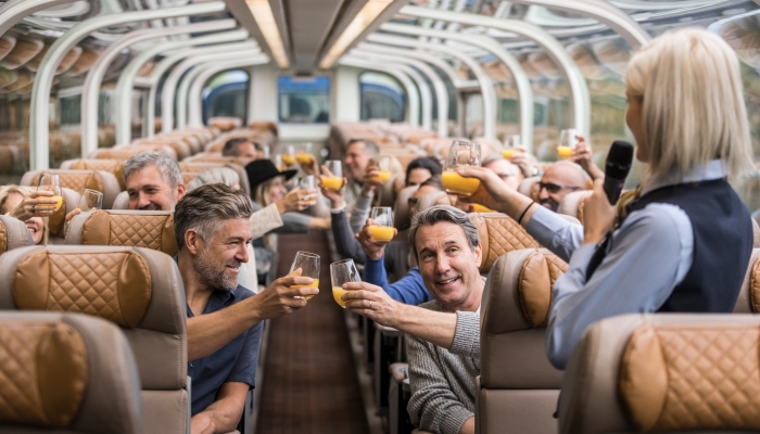 Rocky Mountaineer host and guests raising a toast in a GoldLeaf dome