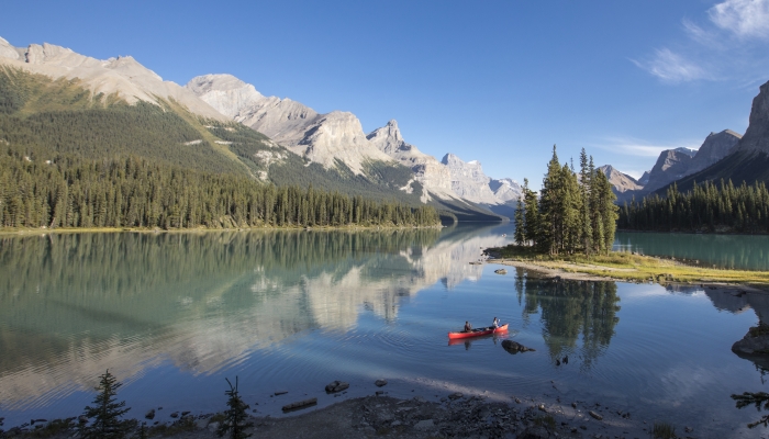 lake with mountains and a couple canoeing in Jasper