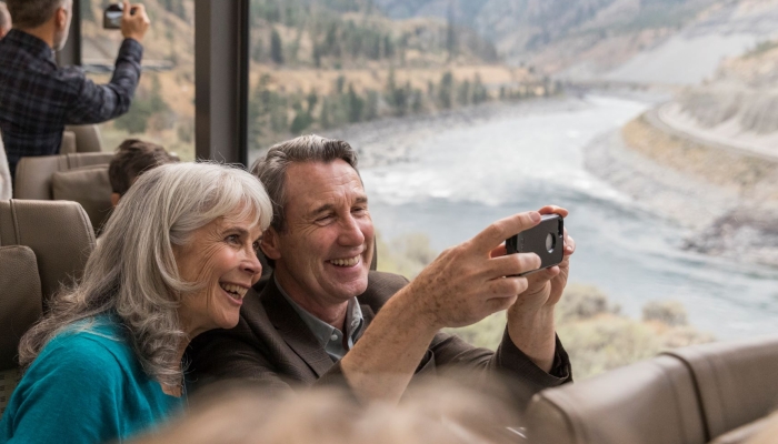 Guests onboard Rocky Mountaineer travelling alongside the Thompson River.