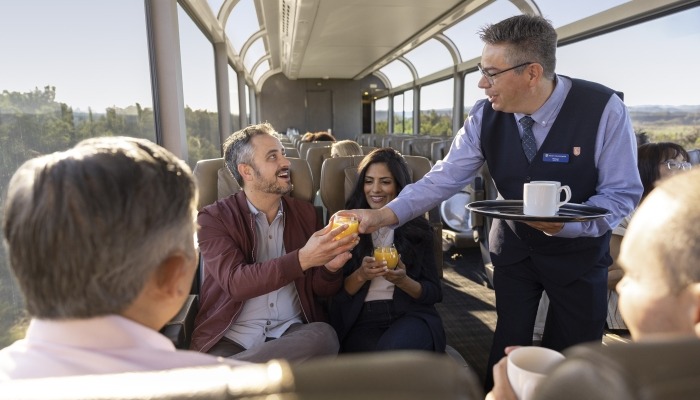 Host serving guests coffee and juice to guests in their seats in SilverLeaf