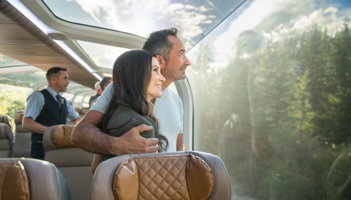 Rocky Mountaineer host and guests raising a toast in a GoldLeaf dome