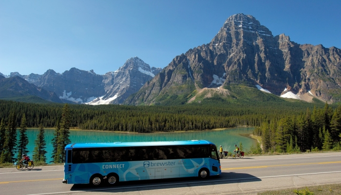 Blue tour bus with a mountain and lake view background