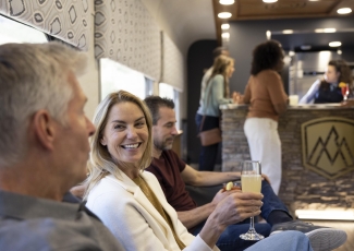 Guest enjoying a cocktail in the SilverLeaf Plus lounge car