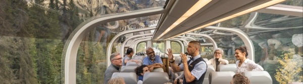 Luxury train passengers enjoying panoramic views from Rocky Mountaineer's glass-dome coach