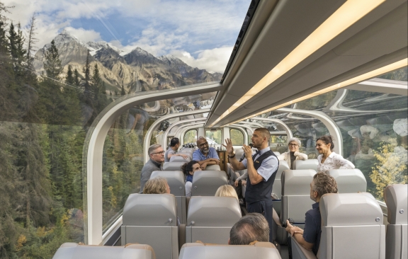 Rocky Mountaineer Host telling stories to guests in a GoldLeaf Dome