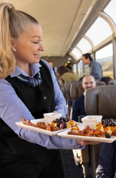 Host serving food on the Rockies to the Red Rocks train.