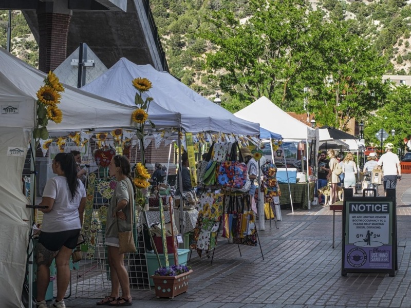 People visiting businesses at a farmer's market