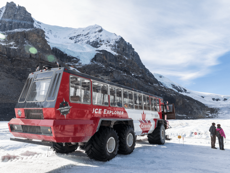 Ice explorer vehicle touring 2 people onto the Athabasca Glacier in the snow