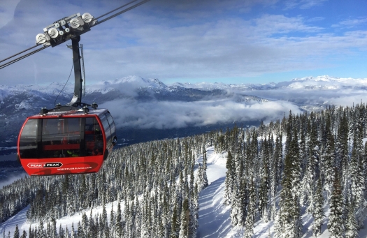 Gondola amidst snowy trees and mountains in Whistler.